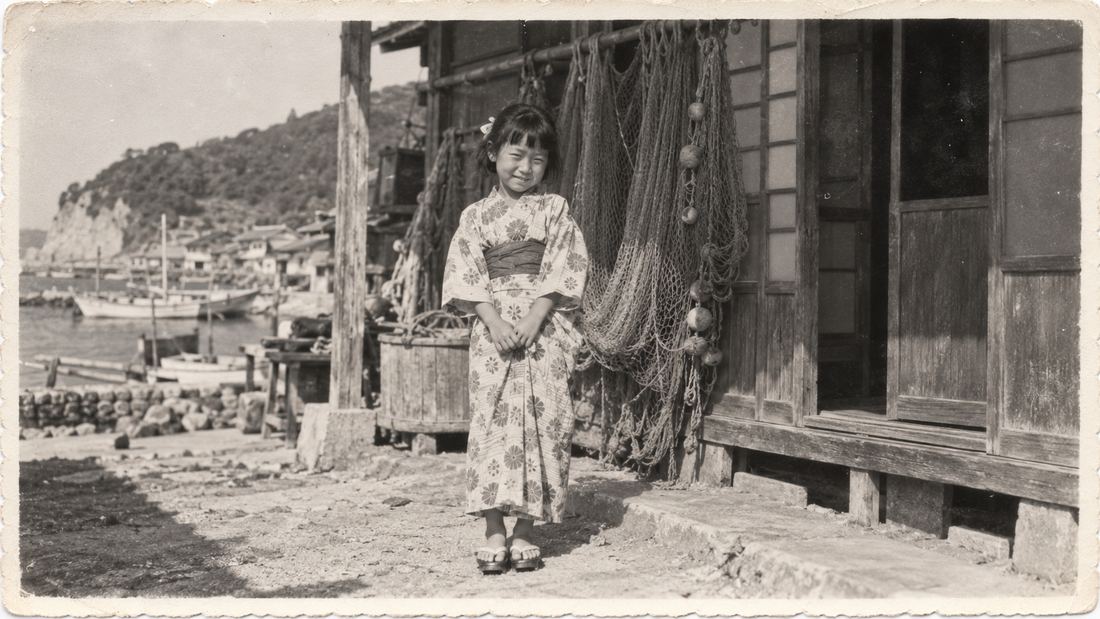 1956年、漁師町の家の前に立つ8歳の女の子(サンプル写真)